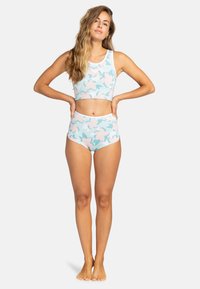 Tiskovaný dvoudílný plavky s modrým pozadím a růžovými květinovými vzory, vyrobené z elastického materiálu pro pohodlí.