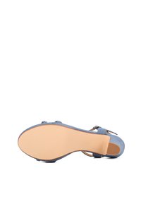 Sandalo blu in suede con suola liscia color marrone chiaro, caratterizzato da una fascia decorativa e una fibbia, progettato per essere indossato con le dita dei piedi scoperte.