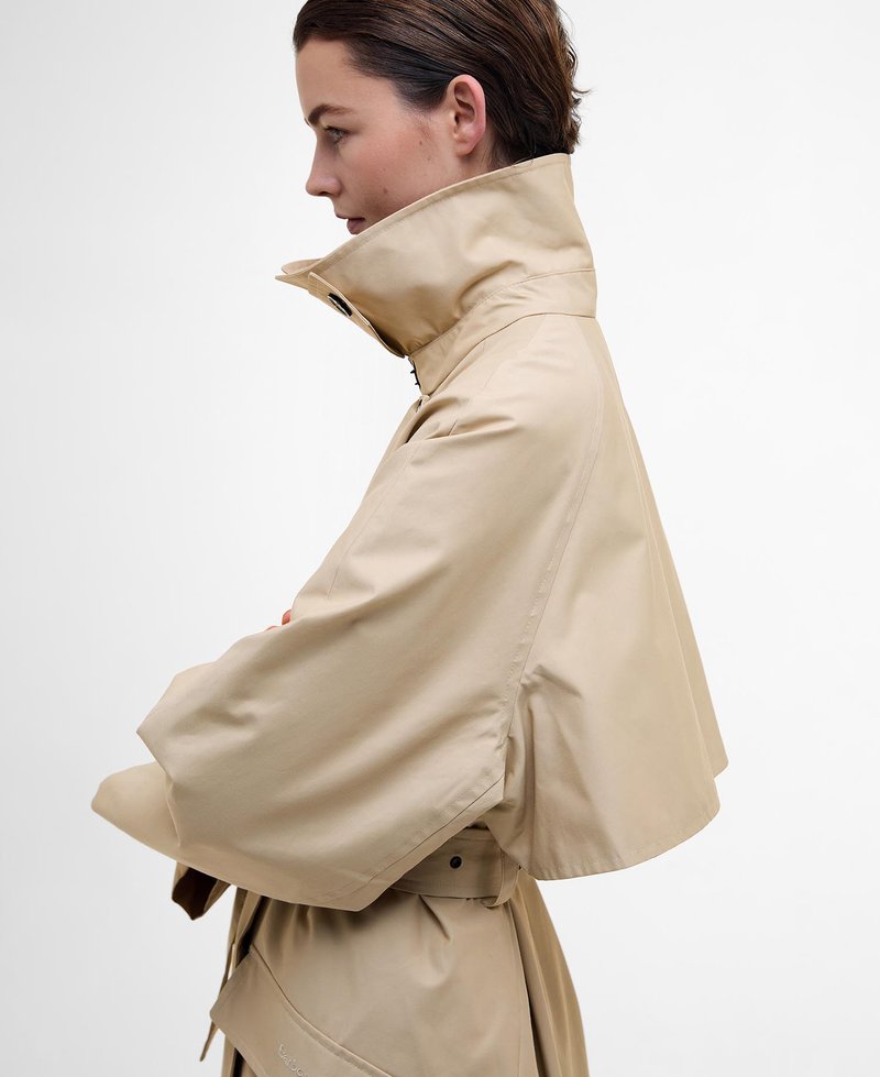 Beige cropped Jacke mit hohem Kragen, weiten Ärmeln und taillierter Taille. Glatte Textur mit minimalem Zubehör und klaren Linien.