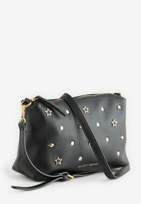 Černá kožená clutch kabelka se zlatými kovovými prvky, zdobená hvězdami a tečkami. Obsahuje zipové uzavírání a odnímatelný popruh.