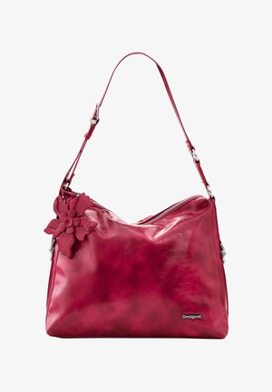 Crvena kožna torba za rame s podesivim remenom, velikim ukrasom u obliku cvijeta sa strane, zatvaranjem na patentni zatvarač i logotipom Desigual sprijeda.