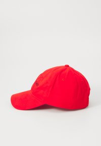 Rode katoenen baseballpet met gebogen vizier, geborduurd logo op de voorkant en zes ventilatie-oogjes. Ronde kroon en een knoop bovenop.