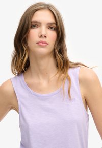 Licht lavendel tanktop met een ronde halslijn en mouwloos ontwerp. Gemaakt van zachte stof, met subtiele branding op de borst.