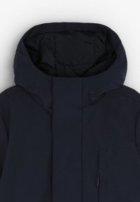 Marineblå hættetrøje med høj krave, lynlås-lukning og en sidelomme med lynlås, lavet af et glat og holdbart stof.