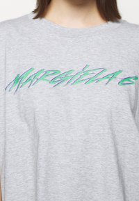 Grå bomullströja med en störd, färgglad "MARGIELA"-logotyp i grönt och lila över framsidan. Design med rund hals och korta ärmar.