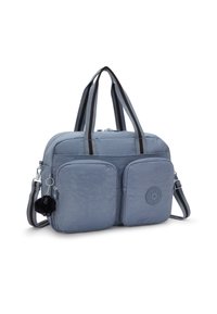 Sac à épaule rectangulaire bleu clair avec des poches zippées avant doubles, des poignées rayées noires et grises, et un petit porte-clés gorille en peluche noir.