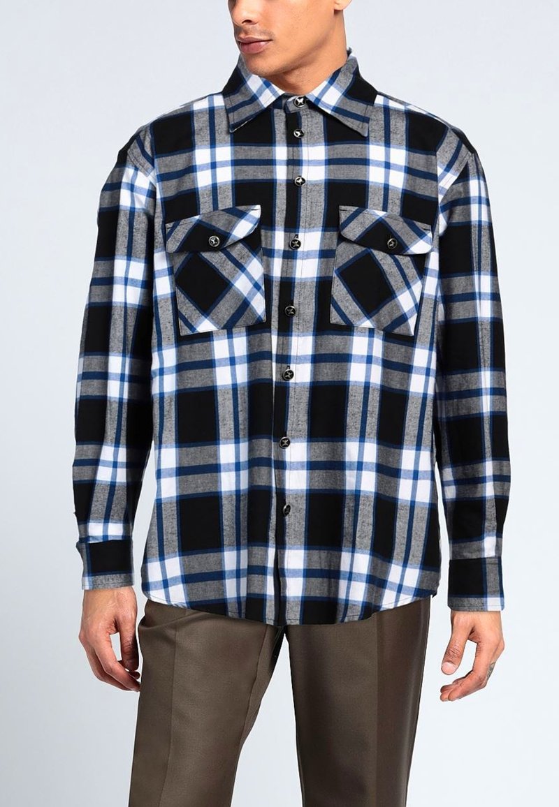 Camicia a quadri in tonalità nere, blu e grigie con ampie tasche sul petto. Maniche lunghe, chiusura con bottoni e colletto. Tessuto morbido.