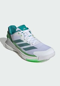 White athletic shoe with a mesh upper, teal accents, green midsole, and textured surface. Designed for performance and comfort.
