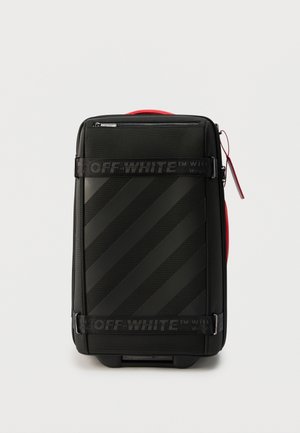 Μαύρη χειραποσκευή Off-White με διαγώνιες ρίγες, λουριά με λογότυπο, κόκκινη πλευρική λαβή και επάνω τσέπη με φερμουάρ.
