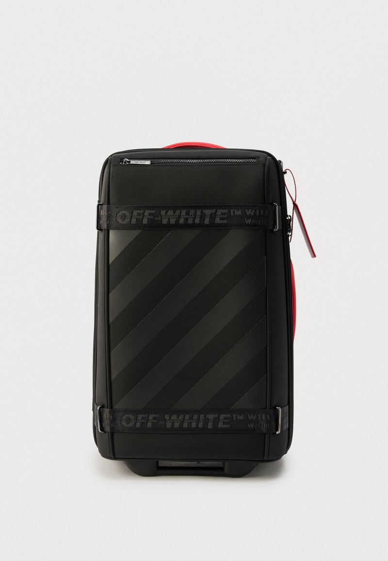 Μαύρη χειραποσκευή Off-White με διαγώνιες ρίγες, λουριά με λογότυπο, κόκκινη πλευρική λαβή και επάνω τσέπη με φερμουάρ.