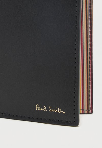 Μαύρο δερμάτινο πορτοφόλι με πολύχρωμες ριγέ εσωτερικές άκρες και χρυσό λογότυπο "Paul Smith" στη μπροστινή γωνία.