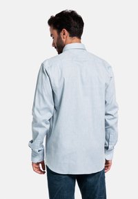 Lichtblauwe, langdure knoopshirts met een gladde textuur en enkele knoopmanchetten, met een klassieke kraag en een gebogen zoom.