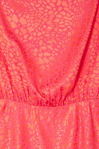 Abito rosa in tessuto lucido e testurizzato con un motivo di ovali grandi e piccoli sparsi; dettaglio della vita elasticizzata visibile.