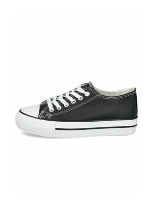 Deportivas negras de caña baja con suela de goma blanca, puntera blanca, cordones blancos y costuras blancas sobre un fondo liso.