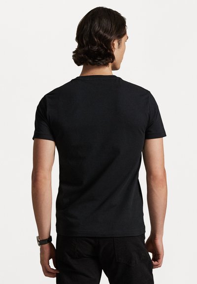 Čierne bavlnené tričko s krátkymi rukávmi a okrúhlym výstrihom, zobrazené zozadu. Hladká textura, žiadne viditeľné vzory alebo grafiky.