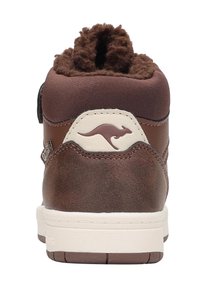 Braune Ledersneaker mit einem texturierten, braunen Stoffkragen, weißer Sohle und gesticktem Känguru-Logo an der Ferse. Das Obermaterial hat eine glatte Oberfläche.