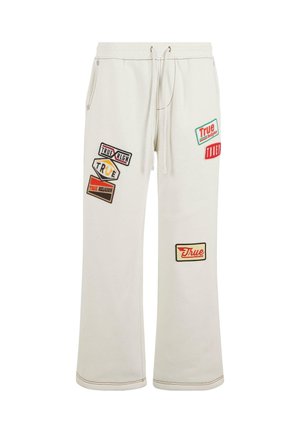 Witte sweatpants met een ontspannen pasvorm, voorzien van meerdere kleurrijke stoffen patches met verschillende etiketten en merken. Trekkoord in de taille.