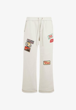 Witte sweatpants met een ontspannen pasvorm, voorzien van meerdere kleurrijke stoffen patches met verschillende etiketten en merken. Trekkoord in de taille.