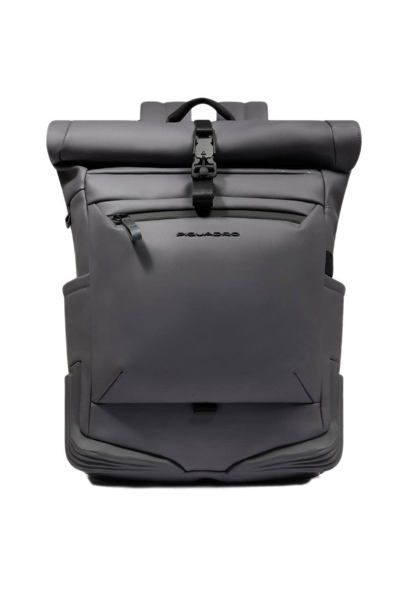 Mochila enrollable gris con un material liso e impermeable. Cuenta con un bolsillo frontal con cremallera y correas ajustables. Diseño minimalista con detalle de logotipo.