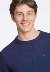 Dunkelblauer Pullover mit Rundhalsausschnitt, aus strukturiertem Stoff. Enthält ein kleines Logo auf der linken Seite der Brust.
