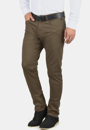 Olijfgroene katoenen broek in een slim fit. Heeft een standaard tailleband, riemlussen en zijzakken. Gecombineerd met zwarte schoenen.
