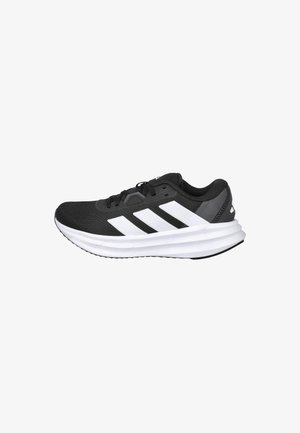 Zapatilla deportiva negra con parte superior de malla ligera, que presenta tres franjas blancas, una plantilla blanca acolchada y suela exterior de goma texturizada.
