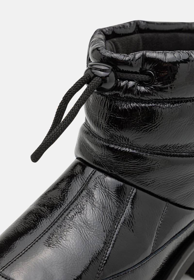 Stivaletto alla caviglia in pelle verniciata nera con una parte superiore imbottita, superficie testurizzata, coulisse regolabile e dettagli di cucitura discreti.