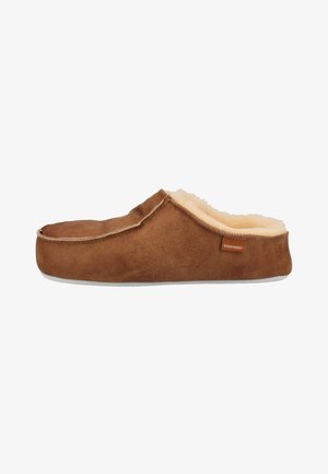 Brown suede slipper featuring a wool lining, flat sole, and a label tag. The design is slip-on with a rounded toe and soft texture.