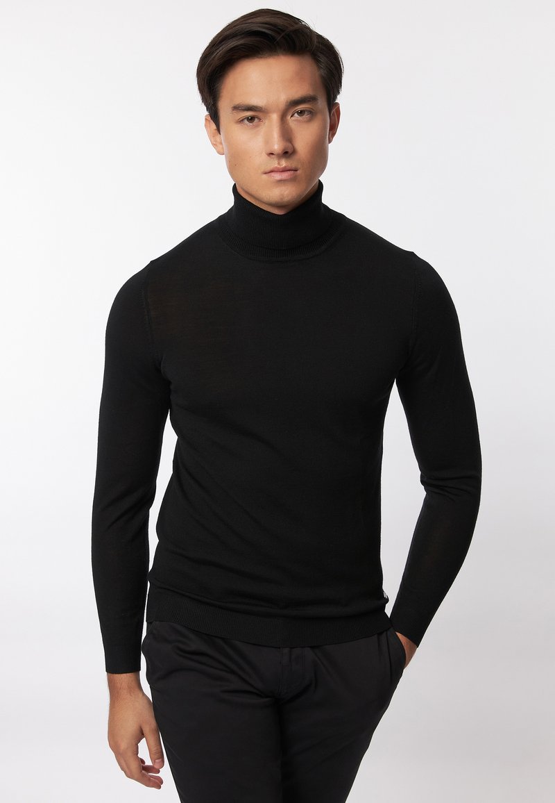 Maglione a collo alto nero con maniche lunghe, realizzato in tessuto leggero. Caratterizzato da un design aderente e da un colletto e polsini a costine.