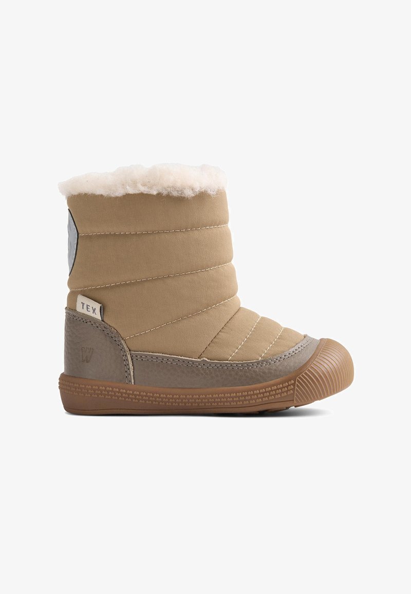 Tanondu soojendusega saabas tikitud kangast, pehme valge voodriga ja pruunast kummist taldaga. Sellel on küljepealne logo ja reljeefsed detailid.