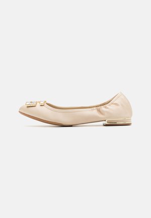 Ballerines en satin beige avec un bout rond, bord élastiqué et un détail en métal doré sur le dessus. Design à talon plat.