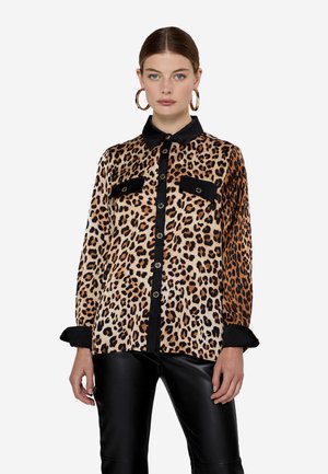Camicia con stampa leopardata, colletto e patte delle tasche neri, con bottoni dorati e maniche lunghe, abbinata a pantaloni in pelle nera.