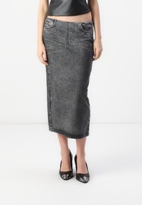 Grå denim midi-skjørt med vertikale striper, frontlommer og en tettsittende design, kombinert med svarte høyhælte sko.