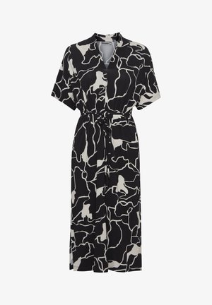 Robe noire et blanche à manches courtes avec un motif abstrait irrégulier, encolure en V, taille cintrée et coupe décontractée. Tissu doux et longueur au genou.