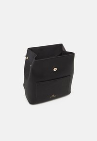 Sac seau ouvert noir avec poche avant et fermeture par bouton doré, fabriqué en matériau lisse avec petit logo doré sur la poche avant.