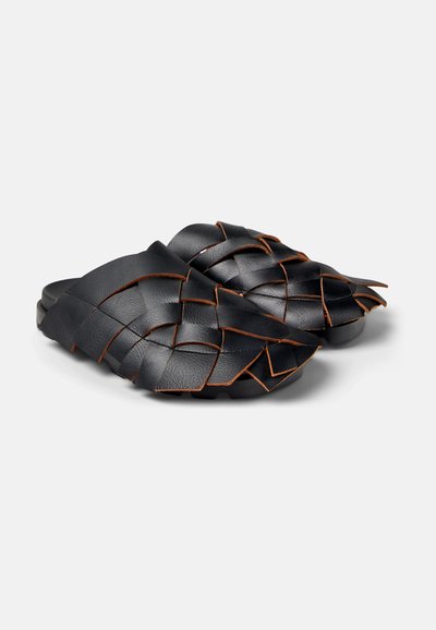 Zwarte leren instapsandalen met een geweven bovenkant, afgewerkt met oranje stiksels en textuur voor extra detail.