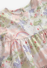 Bomulds kjole med pastelfarvet design med enhjørninger, regnbuer, træer og blomster. Flæsekant, rund halsudskæring og knaplukning bagpå.