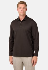 Ilgi piedurkņu polo krekls tumši brūnā audumā, ar pogātu apkakli un sānu birku. Gluda tekstūra, pieguļoša dizaina.