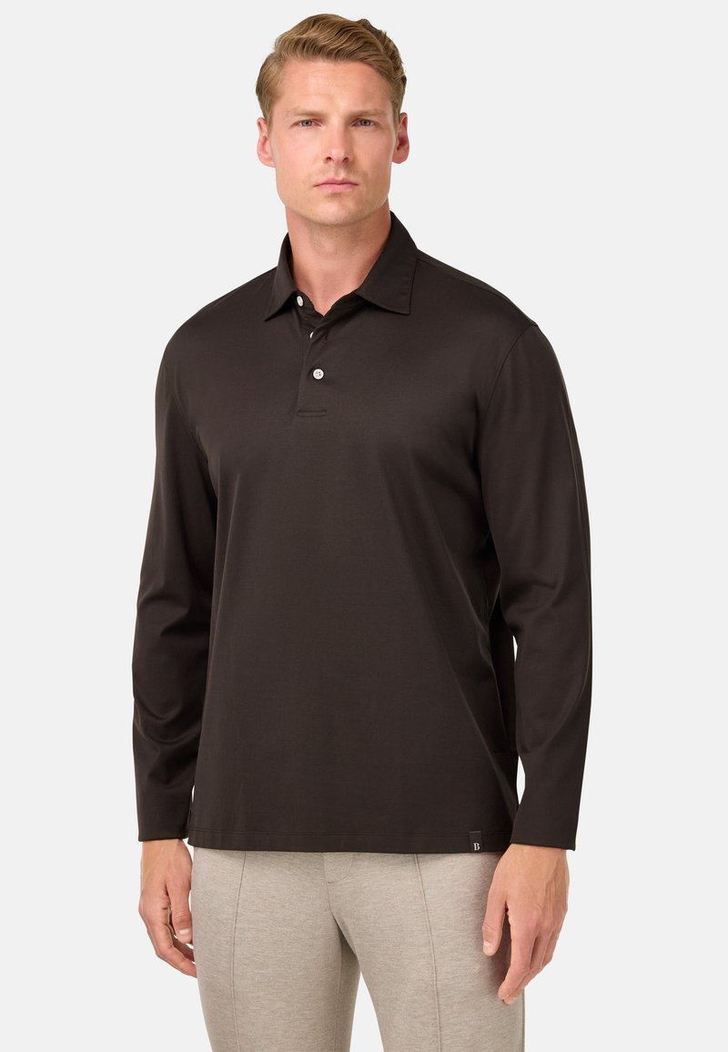 Ilgi piedurkņu polo krekls tumši brūnā audumā, ar pogātu apkakli un sānu birku. Gluda tekstūra, pieguļoša dizaina.