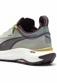 Light green synthetic running shoe with purple accents. Features textured mesh upper, cushioned sole, and yellow heel detail. PUMAGRIP logo on sole.