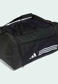 Musta duffel-laukku, jossa on teksturoidusta kankaasta valmistettu pinta, pehmustettu kahva, vetoketjukiinnitys ja valkoiset vinoviivat yhdellä sivulla.