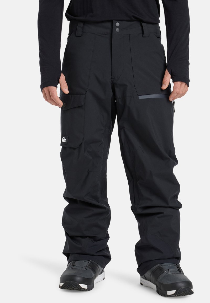 Zwarte sneeuwbroek van waterbestendig materiaal, met een ritszak, een verstelbare tailleband en gebogen knieën voor een gemakkelijke beweging.