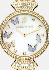 Reloj dorado con una esfera de nácar, que presenta motivos de mariposas y acentos de cristal a lo largo del bisel. Incluye números y logotipo.
