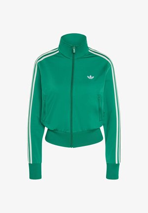 Zeleno sportsko jakna na patent s visokim ovratnikom, bijelim prugama na rukavima i malim bijelim logotipom na prsištu. Mekani, sportski materijal.