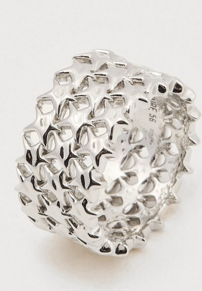 Iarba lata de argint cu un model interconectat de elemente ridicate în formă de stea care acoperă întreaga sa suprafață.