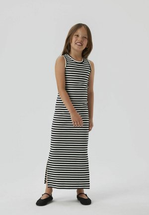 Randig svart- och vit ärmlös maxikjol med ribbad textur, som har en sidoficka och rund halsringning, tillsammans med svarta flats.
