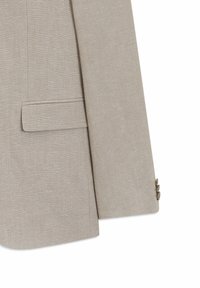 Manche de veste de costume en lin beige et détail de poche à rabat avec trois boutons au poignet, tissu texturé, sur fond blanc.