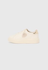 Bijela kožna tenisica s teksturiranim kremastim srednjim đonom, zlatnim detaljima na peti i logotipu te okruglim vezicama. Glatki završetak.