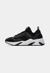 Schwarzer Sportschuh mit Obermaterial aus Mesh und synthetischem Leder, weißer Sohle und strukturierten Akzenten. Verfügt über eine Zuglasche und ein Markenlogo.