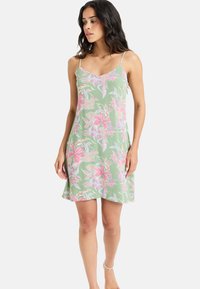 Light green floral dress with thin spaghetti straps, featuring pink and blue floral patterns, a flared hem, and soft, lightweight fabric.